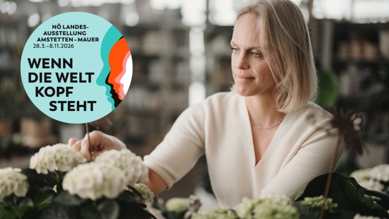 Starkl, © Mostviertel Tourismus/Stefan Voitl Frau betrachtet Pflanzen in einem Gewächshaus mit einem runden Logo der NÖ Landesausstellung 2026 im Vordergrund.