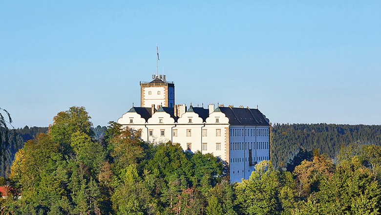 Schloss Weitra, © Waldviertel Tourismus/lichtstark.com Schloss Weitra auf einem bewaldeten Hügel vor blauem Himmel.