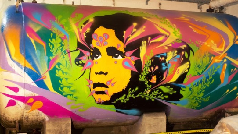 Graffiti Tank Sektkellerei, © Sektkellerei Inführ Graffiti auf einem Tank mit buntem Gesicht und Pflanzenmotiven.