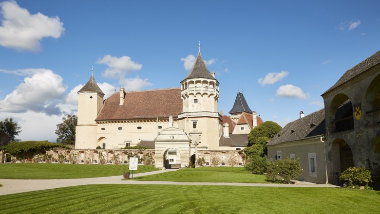 Rosenburg, © Waldviertel Tourismus, Lichtstark Schloss Rosenburg mit Türmen und gepflegtem Rasen unter blauem Himmel.