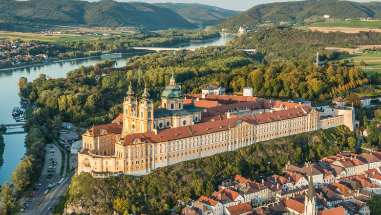 Stift Melk, © Stift Melk, extrem.fotos.com Luftaufnahme des Stifts Melk in Österreich, umgeben von grüner Landschaft und der Donau.