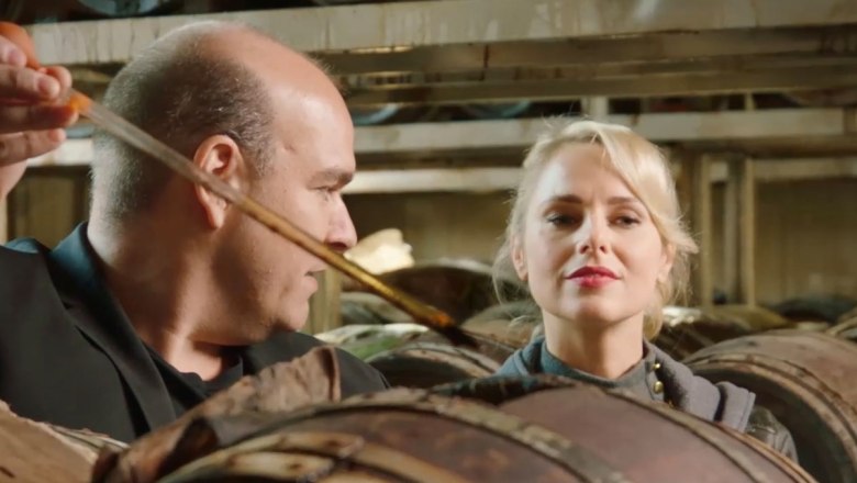 Pecoraro-Balsamico, © Mario Pecoraro Zwei Personen in einer Balsamico-Kellerei, umgeben von Holzfässern.