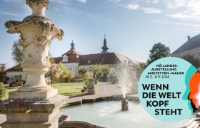 Garten mit Brunnen und Klostergeb&auml;ude im Hintergrund, Plakat f&uuml;r N&Ouml; Landesausstellung 2026.