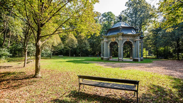 Der Schlosspark Laxenburg l&auml;dt mit seiner idyllischen Atmosph&auml;re und den schattenspendenden B&auml;umen zu einem entspannten Spaziergang ein. Die kunstvoll gestaltete Pavillonstruktur, umgeben von &uuml;ppigem Gr&uuml;n, bietet einen perfekten Ort f&uuml;r eine kleine Auszeit in der Natur.