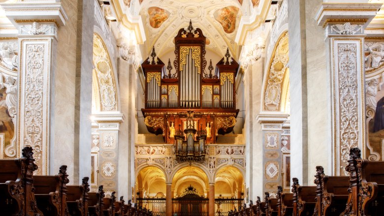 Prächtige Orgel in einer reich verzierten Kirche mit kunstvollen Holzschnitzereien und Fresken.