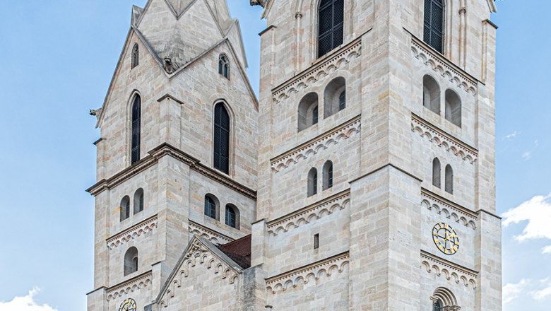 Der Dom von Wiener Neustadt mit zwei markanten Türmen vor blauem Himmel.