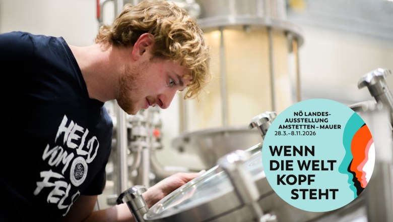 Ein Mann schaut in eine Brauanlage. Ein Logo der NÖ Landesausstellung 2026 ist eingeblendet.