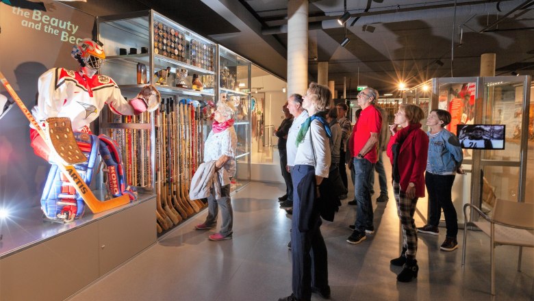 Besucher betrachten eine Eishockey-Ausstellung im Wintersport Museum.