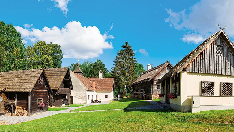 Traditionelle Gebäude im Museumsdorf Krumbach bei sonnigem Wetter.
