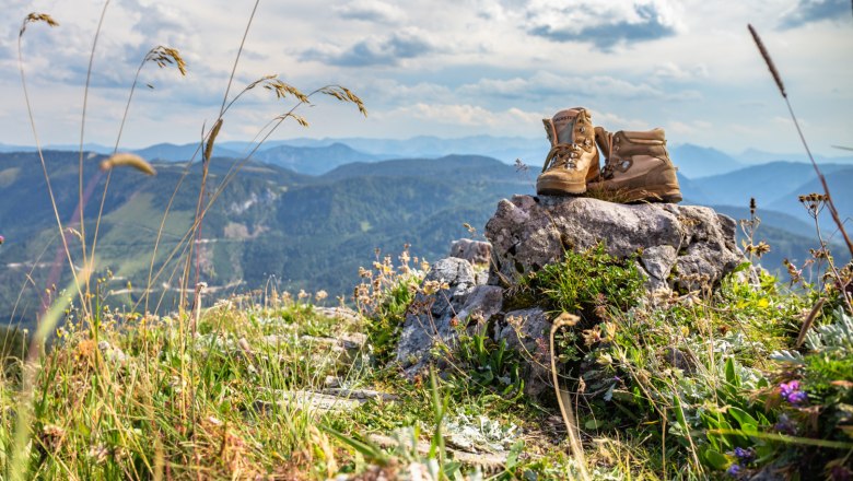 Wanderschuhe auf einem Felsen in einer Berglandschaft.