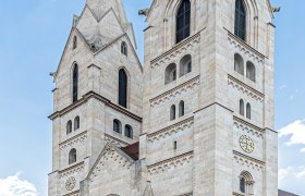 Der Dom von Wiener Neustadt mit zwei markanten Türmen vor blauem Himmel.