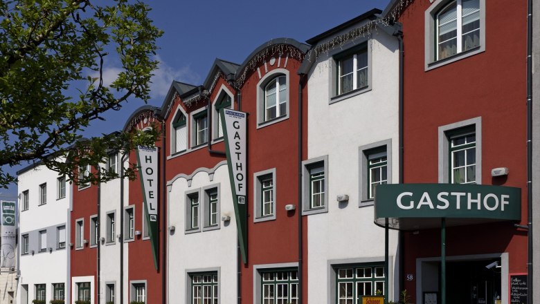 Au&szlig;enansicht des Restaurant-Hotels Wallner mit roter und wei&szlig;er Fassade.