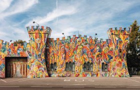 Bunt bemalte Fassade eines Geb&auml;udes in Form einer Burg mit T&uuml;rmen.