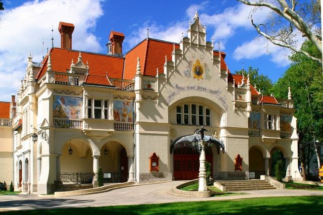 Historisches Gebäude mit rotem Dach und verzierten Fassaden.